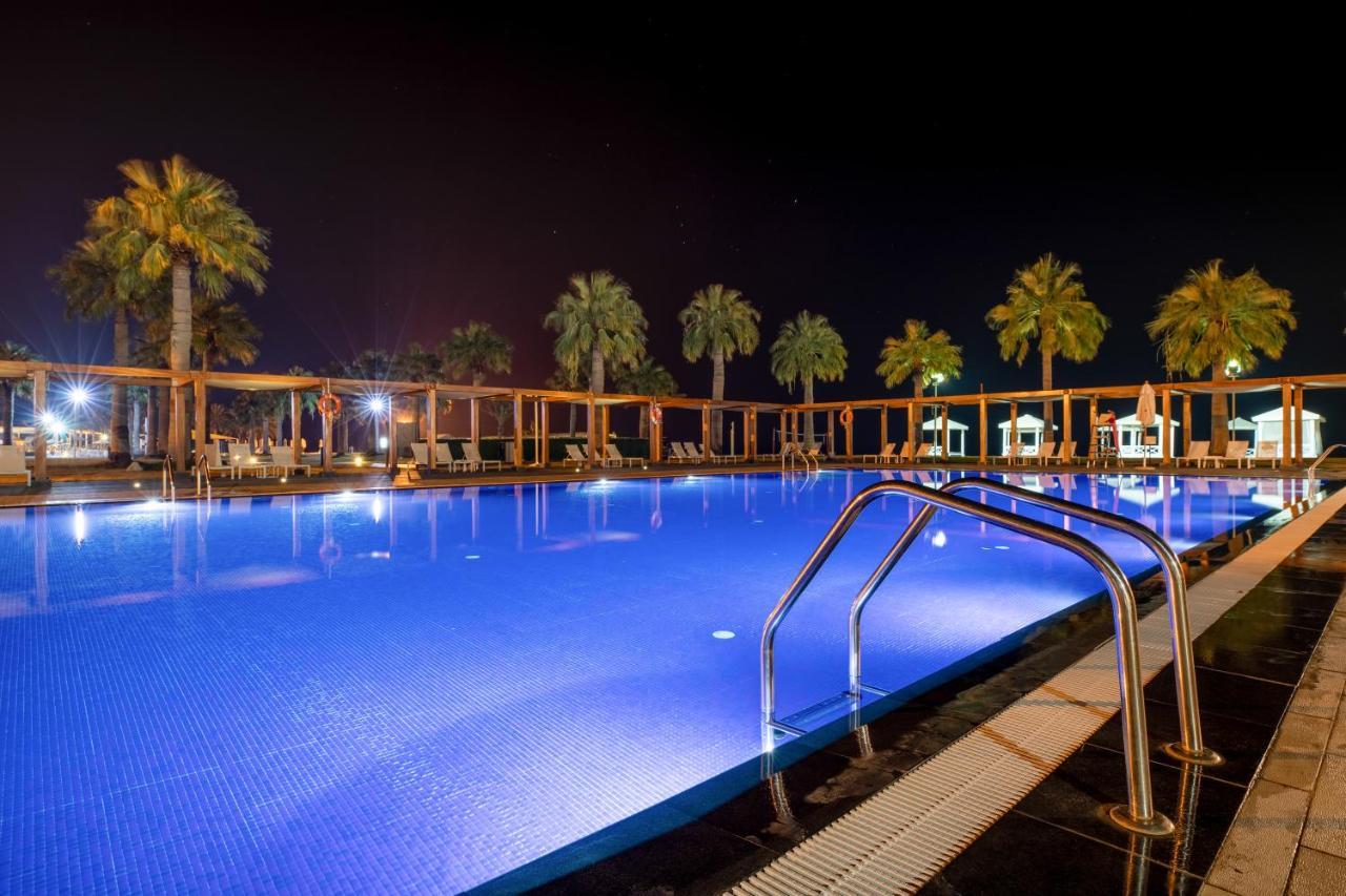 Sealine Beach, A Murwab Resort Месайед Екстериор снимка A swimming pool at night